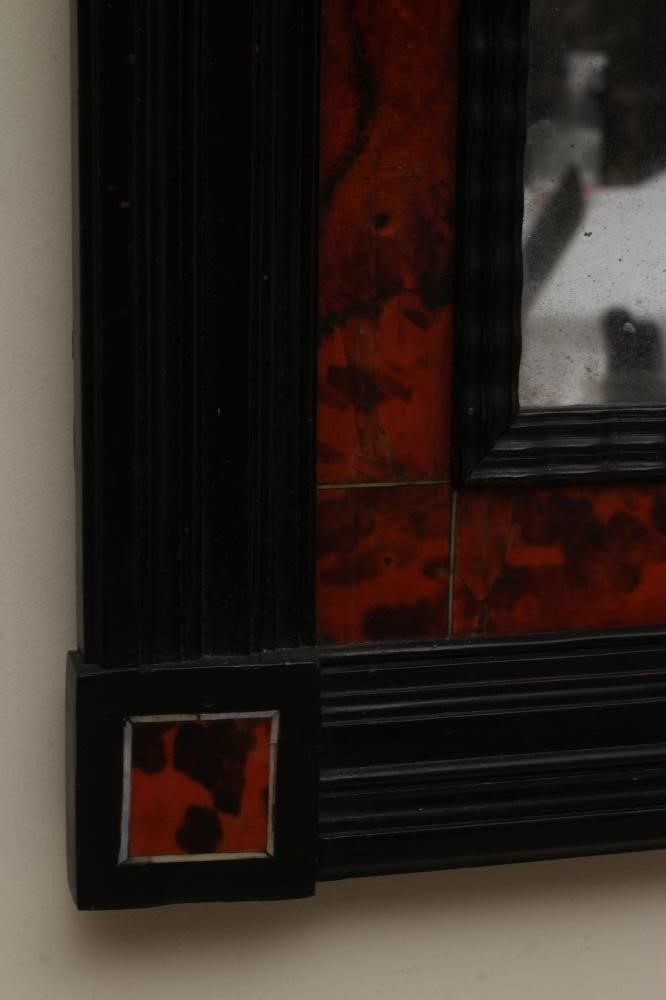 A RED TORTOISESHELL AND EBONY WALL MIRROR Image