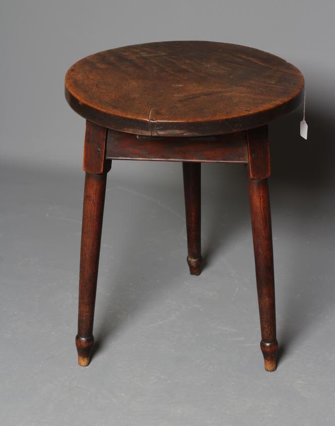 AN OAK AND FRUITWOOD(?) CRICKET TABLE, 19th century, the heavy circular top on turned tapering legs Image
