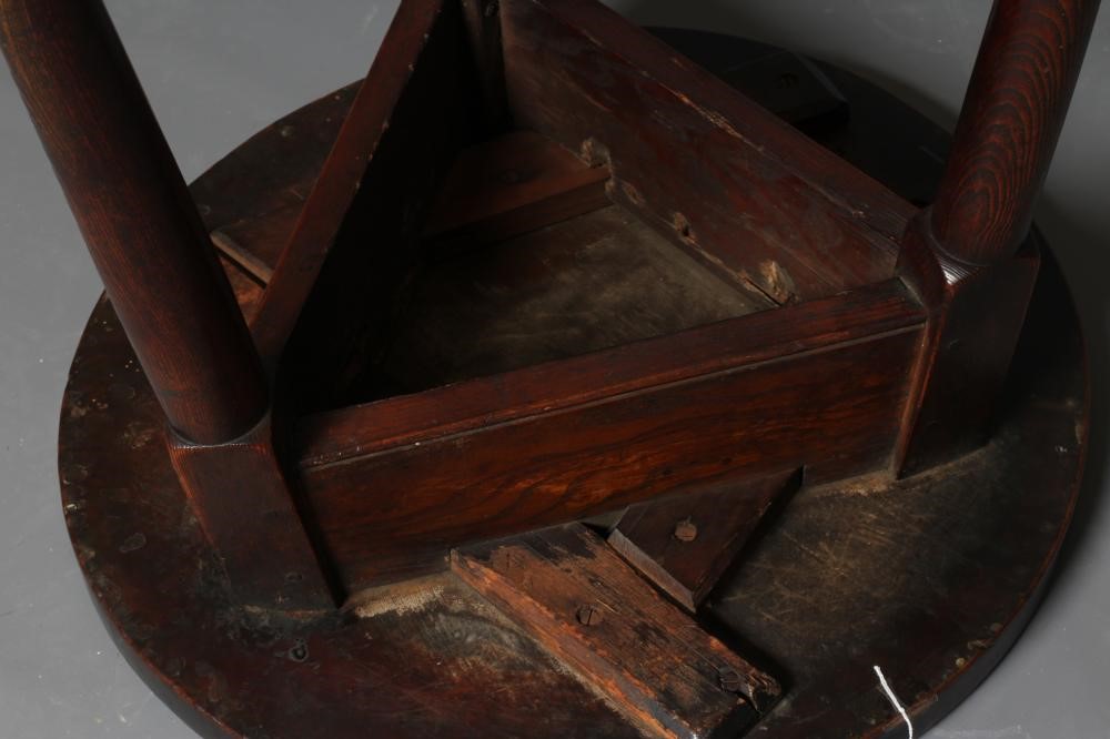 AN OAK AND FRUITWOOD(?) CRICKET TABLE, 19th century, the heavy circular top on turned tapering legs Image