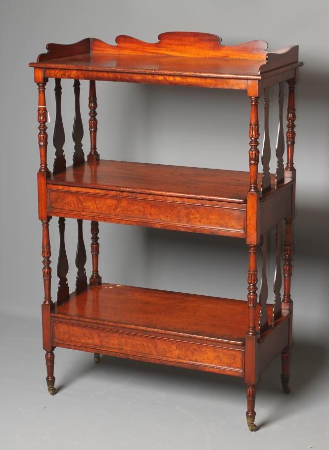 AN EARLY VICTORIAN MAHOGANY WHATNOT of three tier oblong form with waved three quarter gallery Image