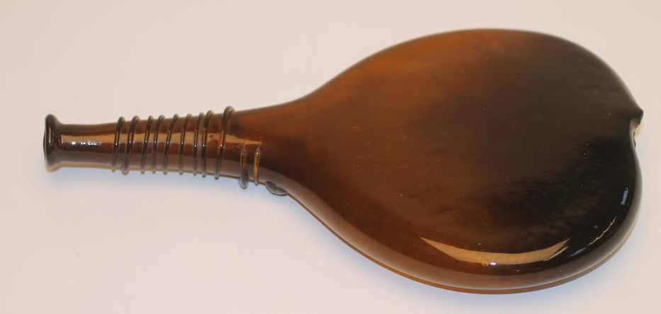 A DARK AMBER GLASS "SADDLE" FLASK Image