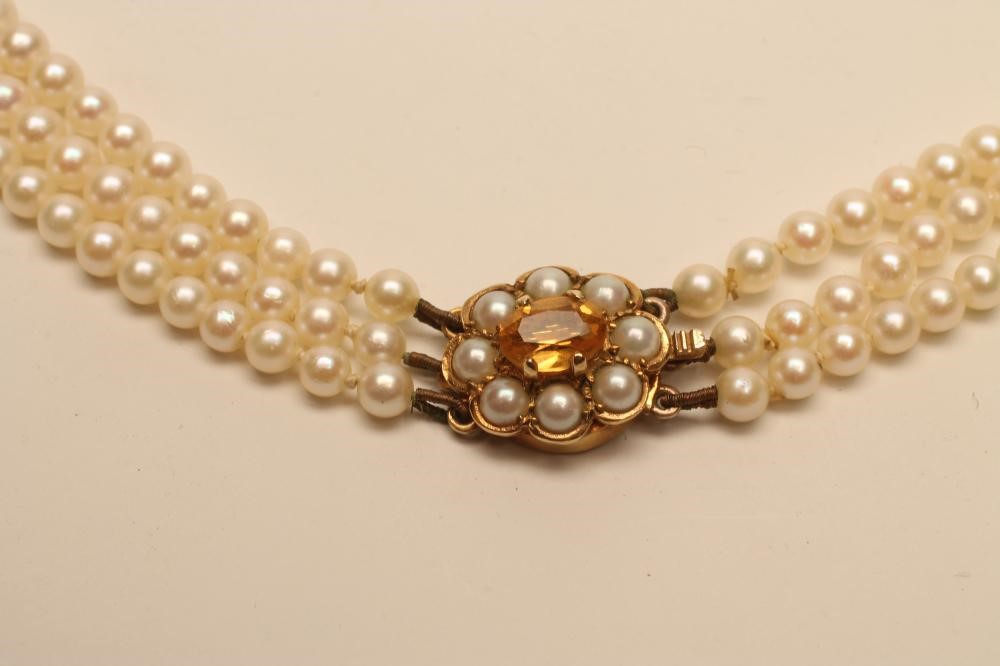 A TRIPLE STRAND CULTURED PEARL NECKLACE Image