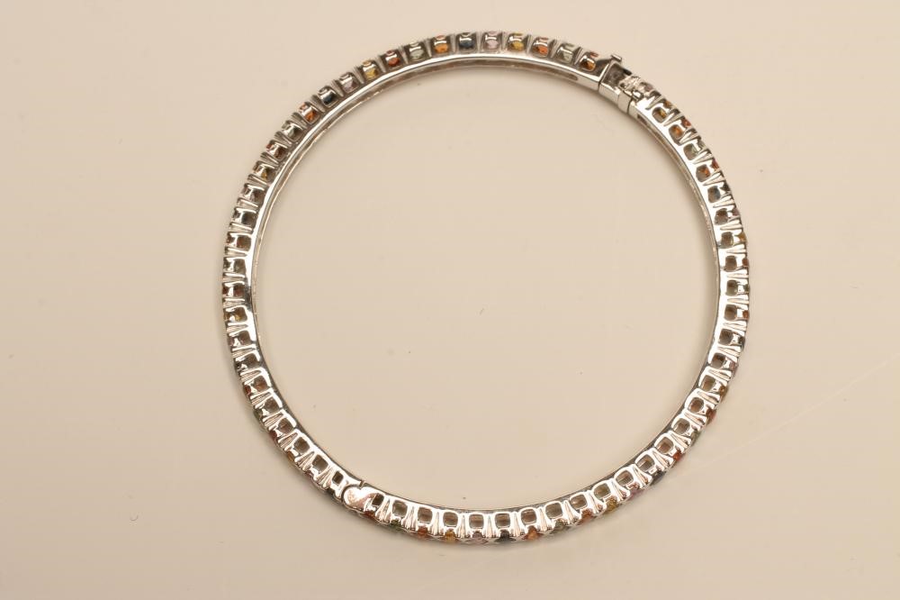 A MULTI-COLOURED SAPPHIRE STIFF HINGED BANGLE Image
