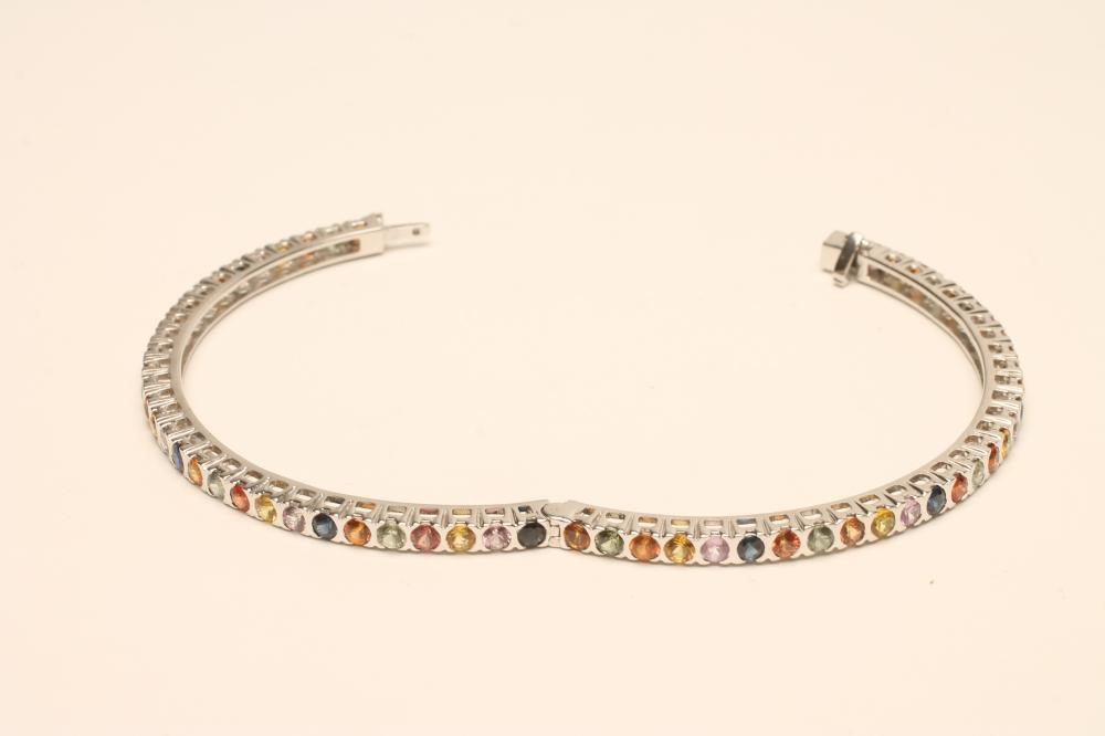 A MULTI-COLOURED SAPPHIRE STIFF HINGED BANGLE Image
