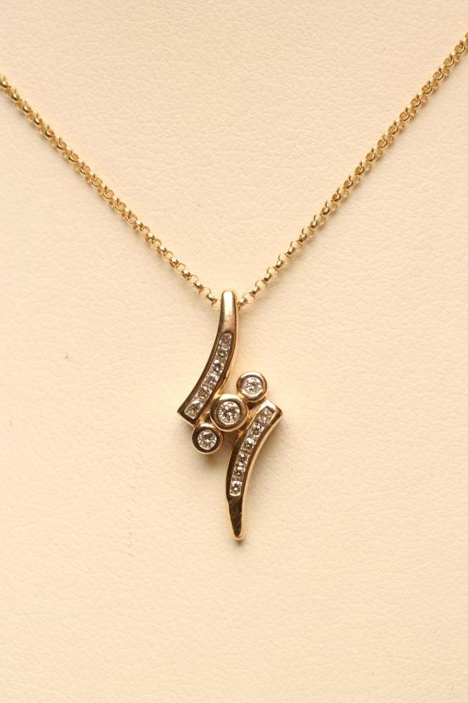 A DIAMOND PENDANT centred by three open back collet set stones within two curved bars Image