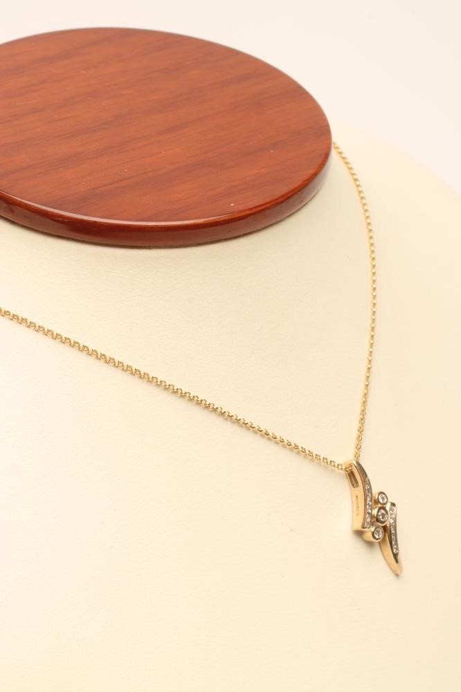 A DIAMOND PENDANT centred by three open back collet set stones within two curved bars Image