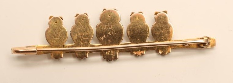 A TRI COLOUR GOLD NOVELTY BAR BROOCH modelled as five owls perched upon a naturalistically cast Image