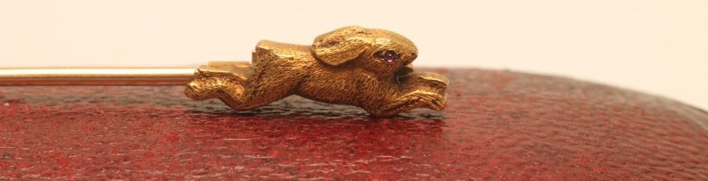 AN EDWARDIAN 15CT GOLD NOVELTY TIE PIN modelled as a hound chasing a rabbit Image
