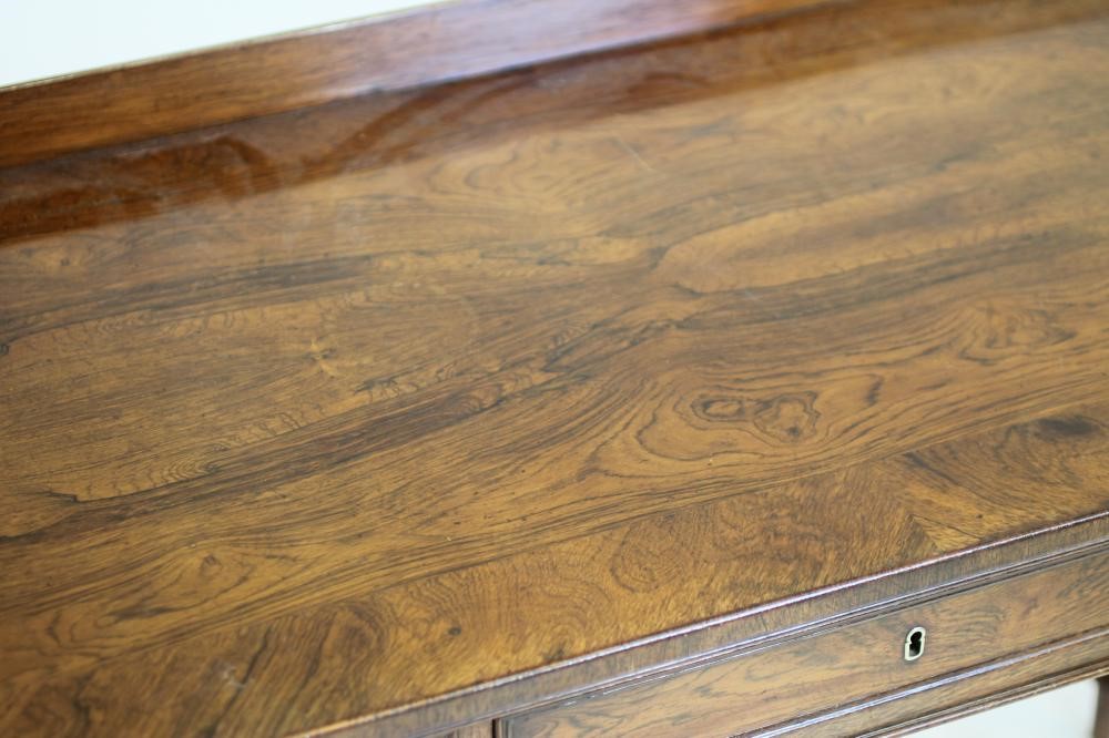 A NAPOLEON III ROSEWOOD WRITING TABLE of oblong form with protruding corners on turned tapering Image