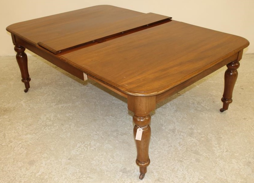 A VICTORIAN MAHOGANY DINING TABLE of rounded oblong form with pull out action and a separate leaf Image