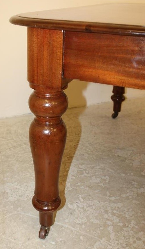 A VICTORIAN MAHOGANY DINING TABLE of rounded oblong form with pull out action and a separate leaf Image