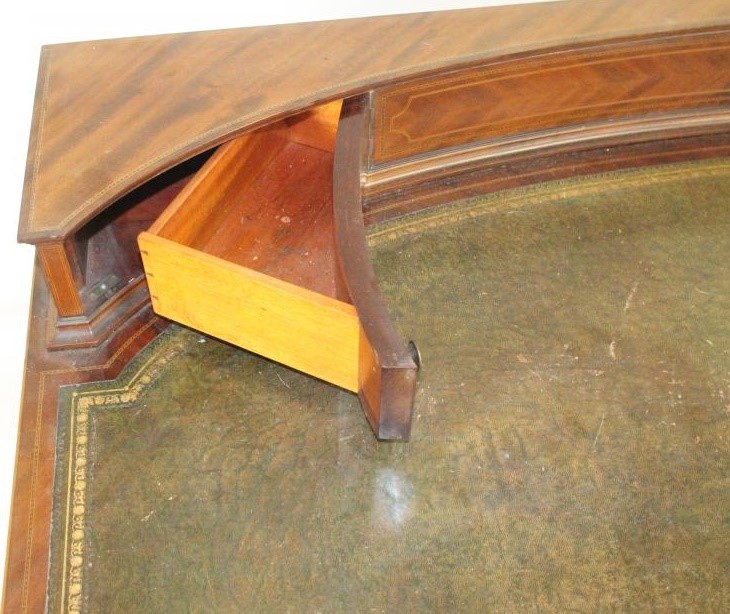 AN EDWARDIAN MAHOGANY DESK of bowed form with stringing and chequer banding Image