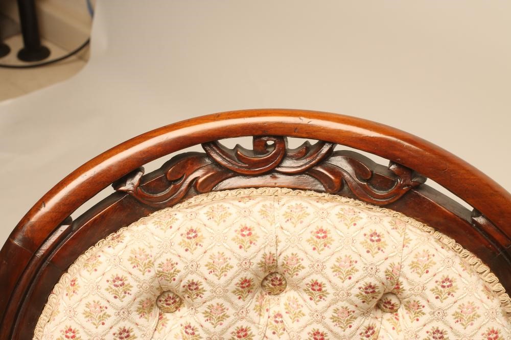A VICTORIAN WALNUT FRAMED NURSING CHAIR of spoonback form button upholstered in a floral ivory weave Image