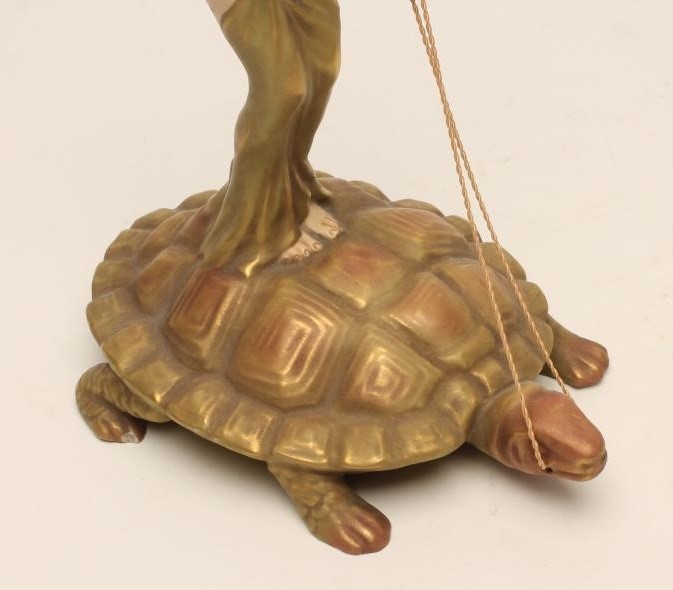 AN ART NOUVEAU ROYAL DUX BISQUE PORCELAIN FIGURE modelled as a naked maiden standing on the back of Image