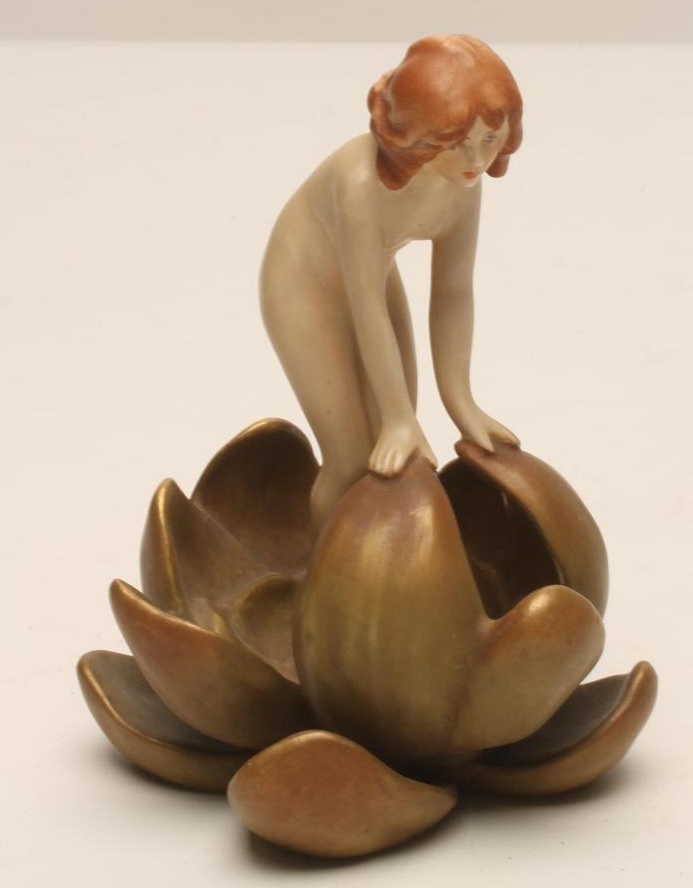 AN ART NOUVEAU ROYAL DUX BISQUE PORCELAIN SMALL FIGURE modelled as a naked maiden standing in a Image