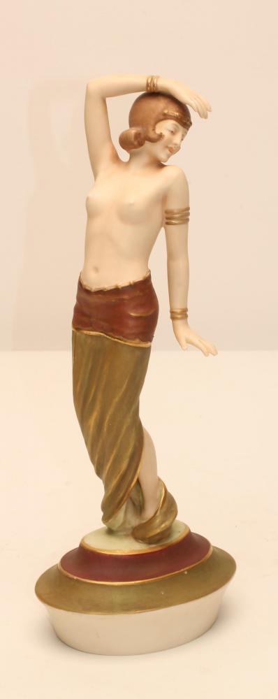 AN ART DECO ROYAL DUX BISQUE PORCELAIN FIGURE modelled as a semi nude young maiden wearing an Image