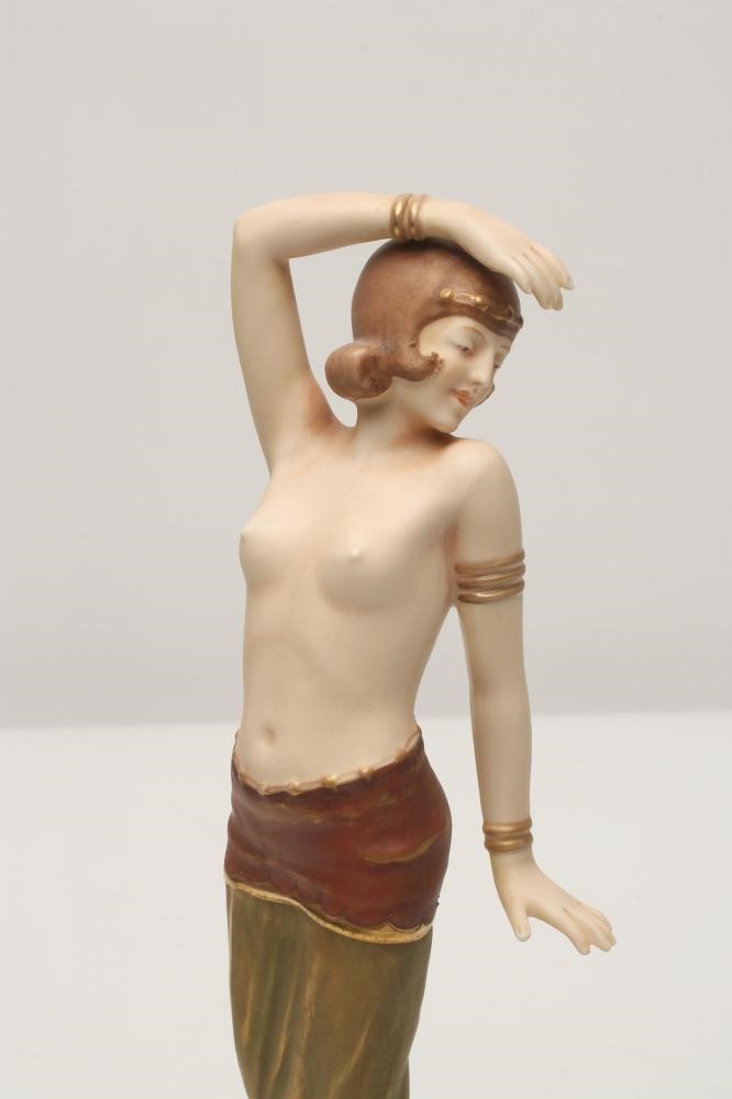 AN ART DECO ROYAL DUX BISQUE PORCELAIN FIGURE modelled as a semi nude young maiden wearing an Image