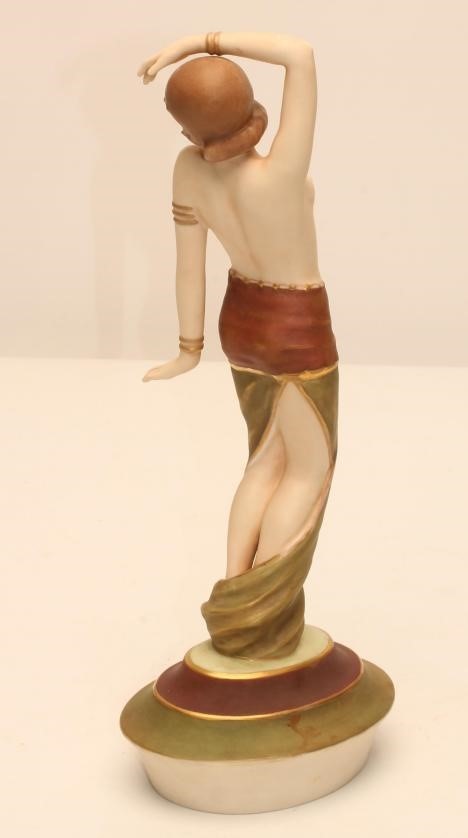 AN ART DECO ROYAL DUX BISQUE PORCELAIN FIGURE modelled as a semi nude young maiden wearing an Image