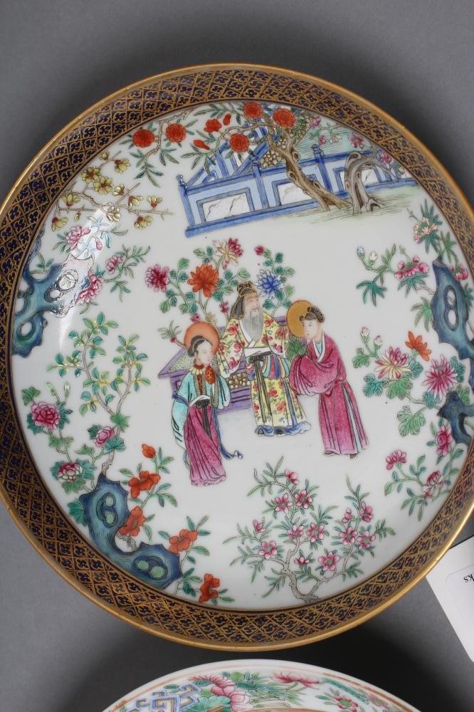 A CHINESE PORCELAIN FAMILLE ROSE SAUCER painted with three figures in a garden within a blue and Image