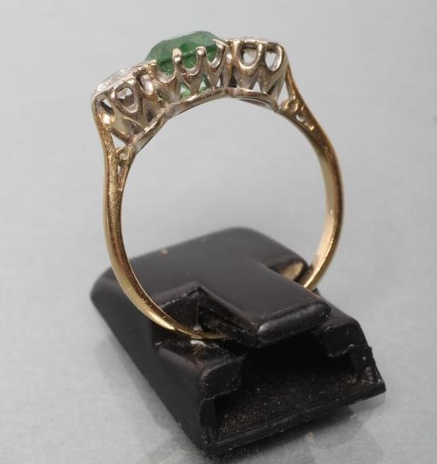 AN EMERALD AND DIAMOND THREE STONE RING Image