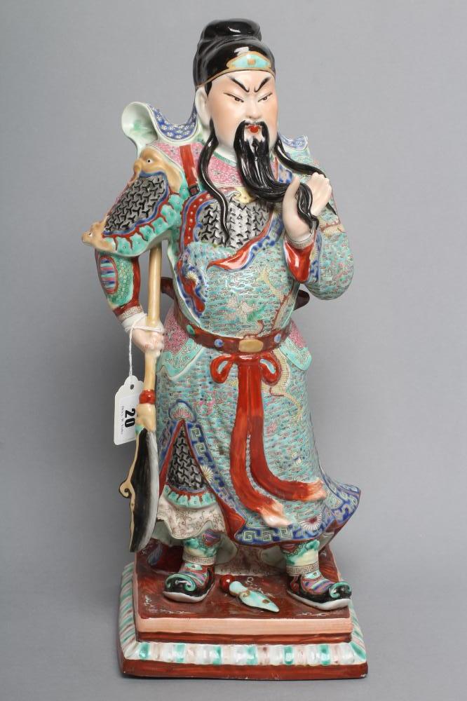 A CHINESE PORCELAIN FIGURE modelled as a celestial warrior wearing brightly coloured robes holding a Image