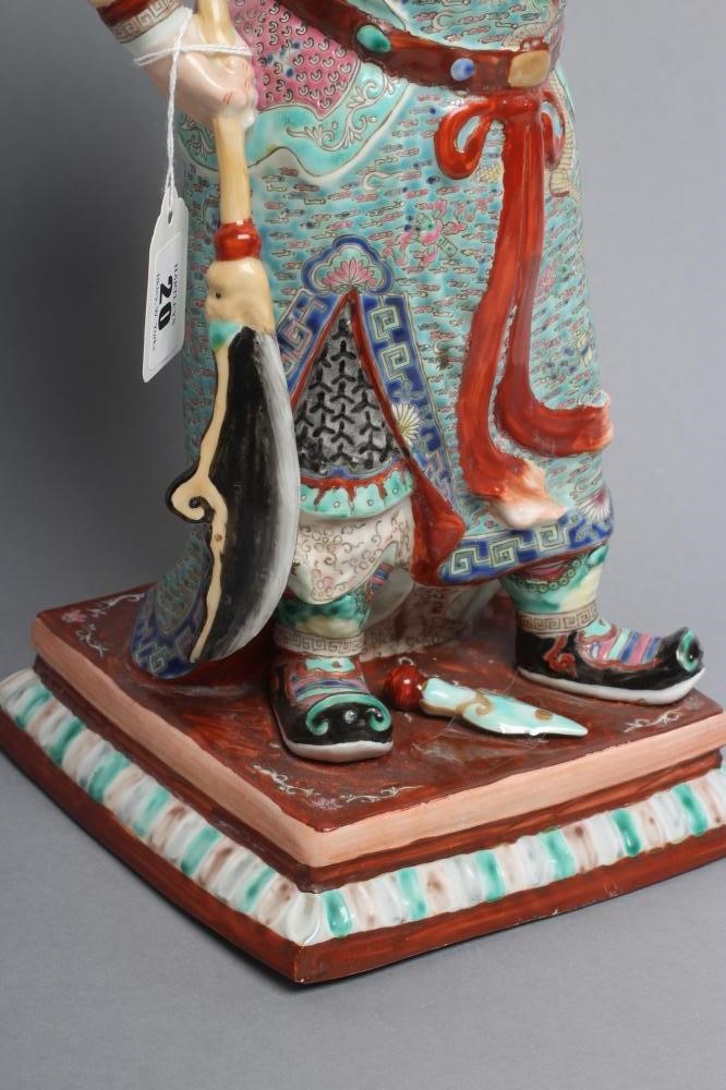 A CHINESE PORCELAIN FIGURE modelled as a celestial warrior wearing brightly coloured robes holding a Image