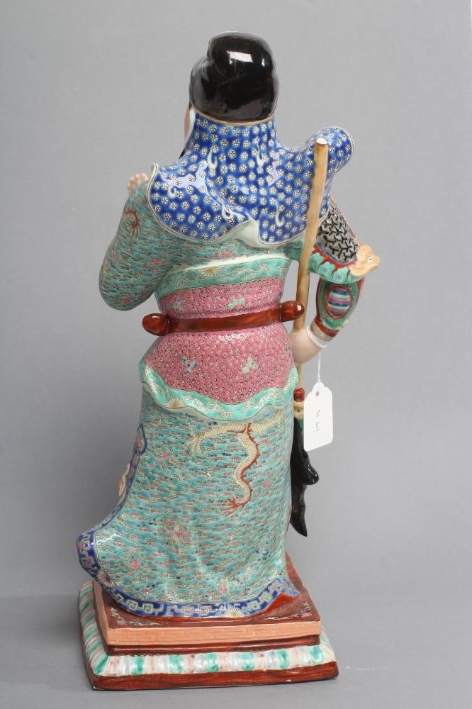 A CHINESE PORCELAIN FIGURE modelled as a celestial warrior wearing brightly coloured robes holding a Image