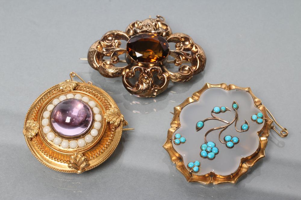 THREE VICTORIAN BROOCHES comprising a boss centred by an amethyst coloured cabochon within coral Image