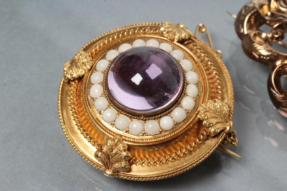 THREE VICTORIAN BROOCHES comprising a boss centred by an amethyst coloured cabochon within coral Image