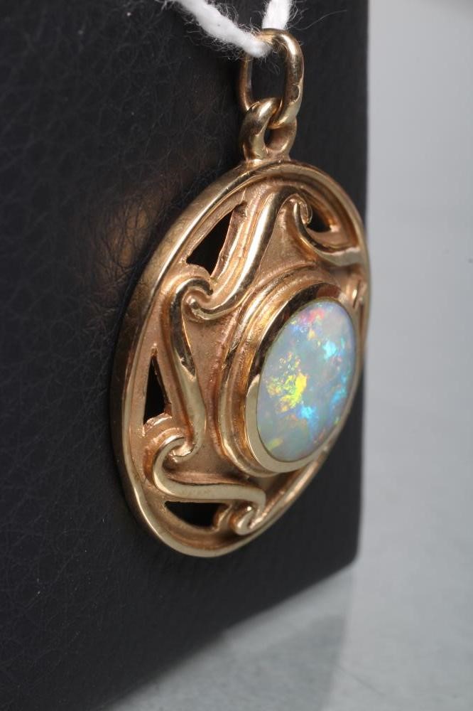 AN ARTS AND CRAFTS STYLE 9CT GOLD BOSS PENDANT centred by a close back set opal doublet(?) within a Image