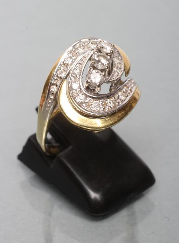 A DIAMOND DRESS RING diagonally set with three stones to an open whorl pave set with numerous Image