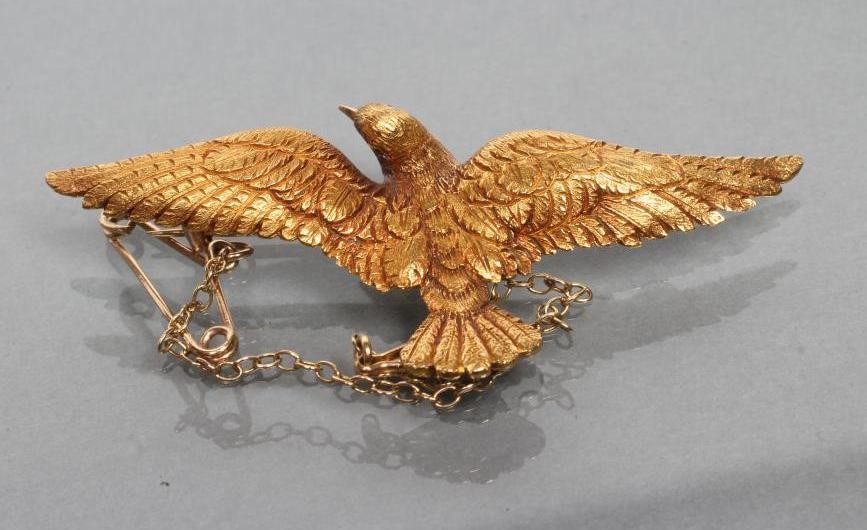 A LATE VICTORIAN DOVE IN FLIGHT BROOCH with chased feathers and ruby eyes Image