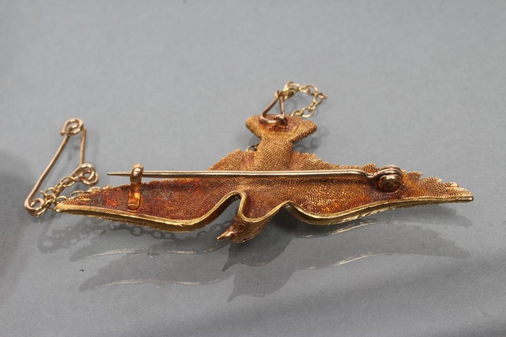 A LATE VICTORIAN DOVE IN FLIGHT BROOCH with chased feathers and ruby eyes Image