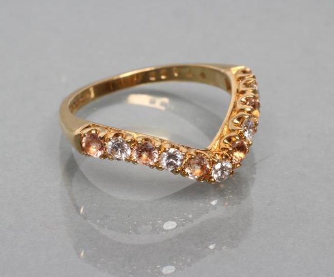 A WISHBONE RING to match the previous lot set with eleven stones to a plain 18ct gold shank Image
