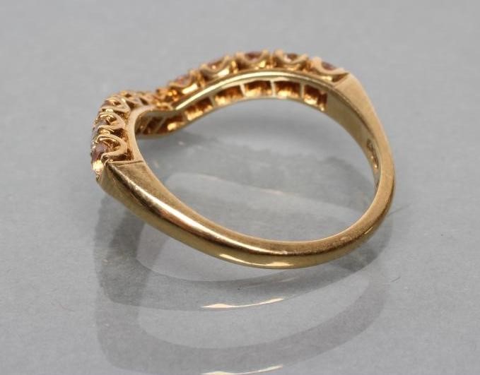 A WISHBONE RING to match the previous lot set with eleven stones to a plain 18ct gold shank Image