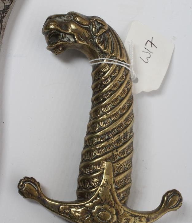 A SHAMSHIR with 26 3/4" curved blade and brass hilt with scalloped grip and lion head pommel Image