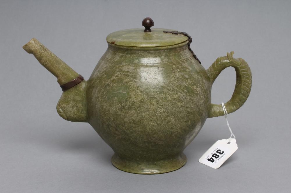 AN INDIAN CARVED AND POLISHED GREEN STONE TEAPOT of globular form with loop handle Image
