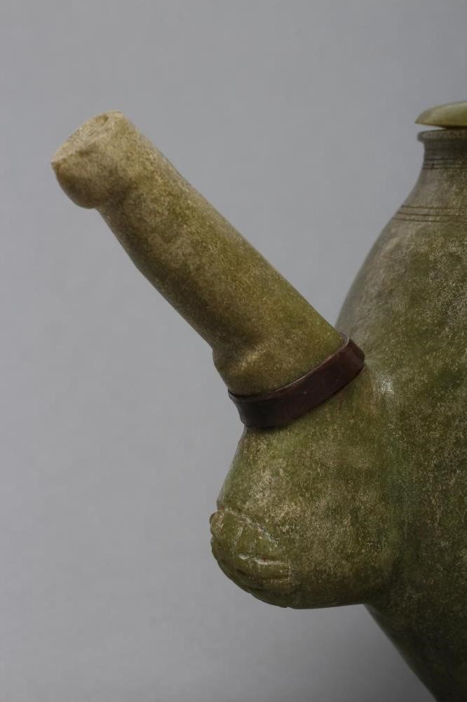AN INDIAN CARVED AND POLISHED GREEN STONE TEAPOT of globular form with loop handle Image