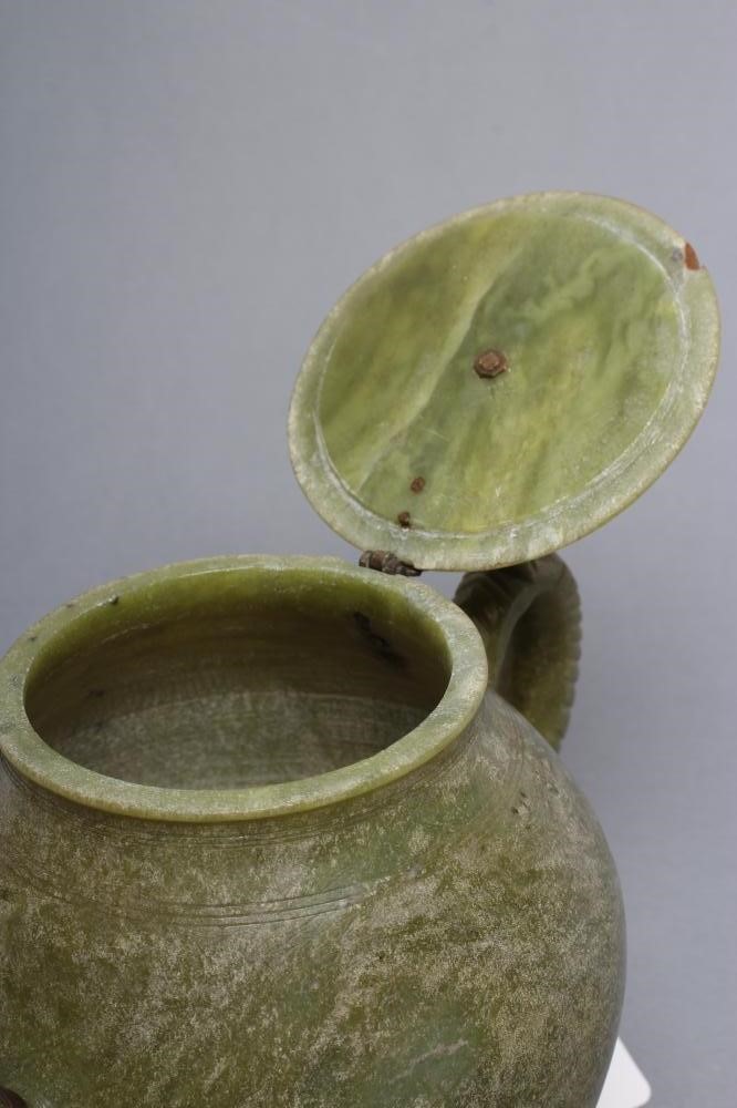 AN INDIAN CARVED AND POLISHED GREEN STONE TEAPOT of globular form with loop handle Image