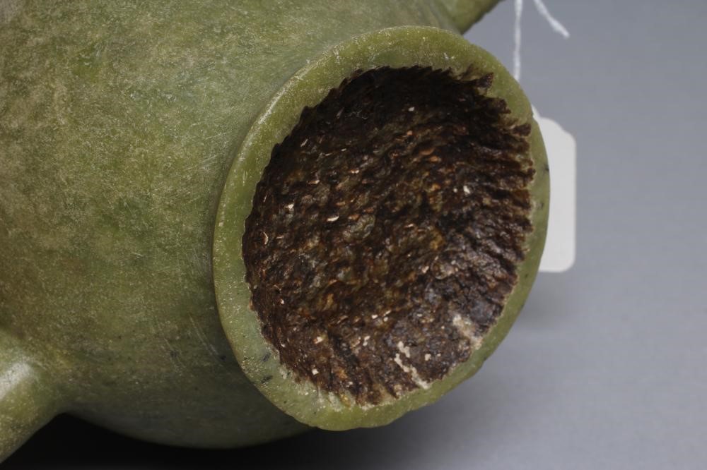 AN INDIAN CARVED AND POLISHED GREEN STONE TEAPOT of globular form with loop handle Image