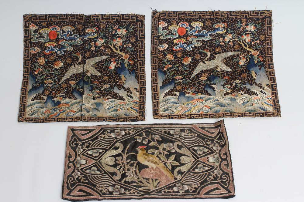 A PAIR OF CHINESE SILK SQUARE PANELS embroidered in coloured silks on a dark navy ground Image