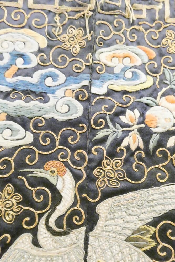 A PAIR OF CHINESE SILK SQUARE PANELS embroidered in coloured silks on a dark navy ground Image