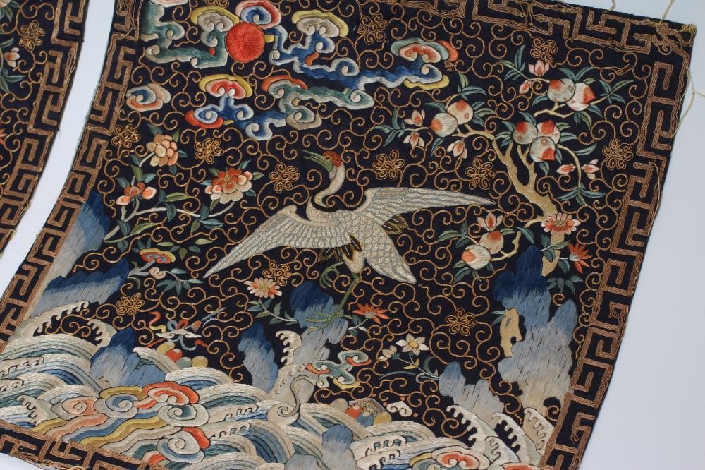 A PAIR OF CHINESE SILK SQUARE PANELS embroidered in coloured silks on a dark navy ground Image
