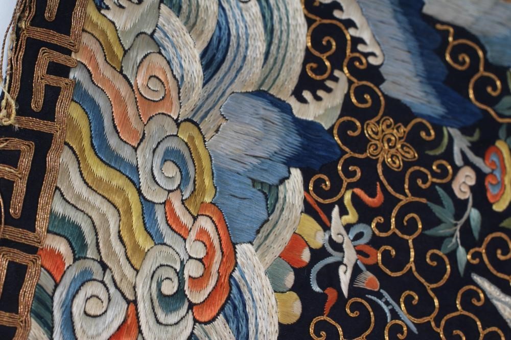 A PAIR OF CHINESE SILK SQUARE PANELS embroidered in coloured silks on a dark navy ground Image
