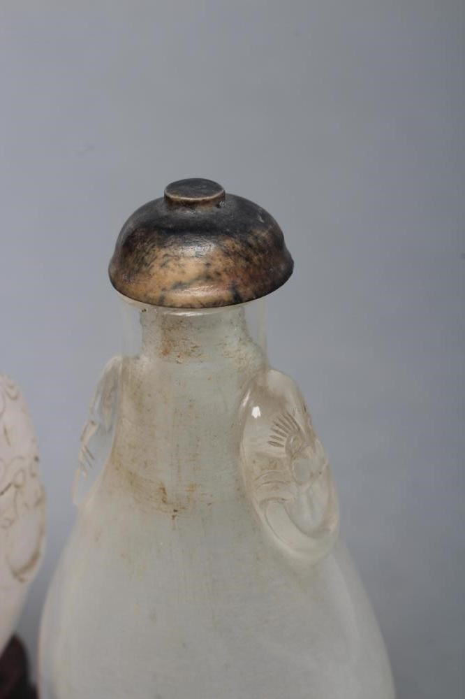 A CHINESE WHITE OPAQUE CRYSTAL SNUFF BOTTLE carved in relief with two mask ring handles Image