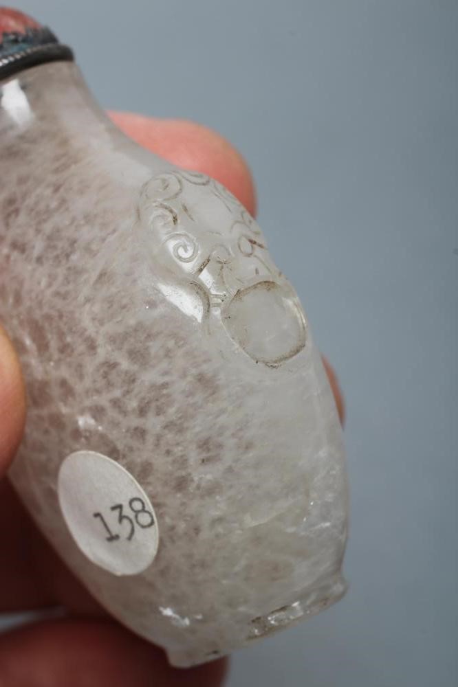 A CHINESE WHITE OPAQUE CRYSTAL SNUFF BOTTLE carved in relief with two mask ring handles Image