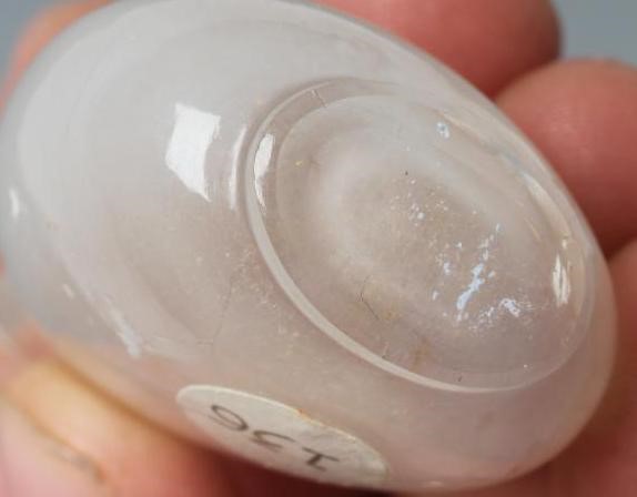 A CHINESE WHITE OPAQUE CRYSTAL SNUFF BOTTLE carved in relief with two mask ring handles Image