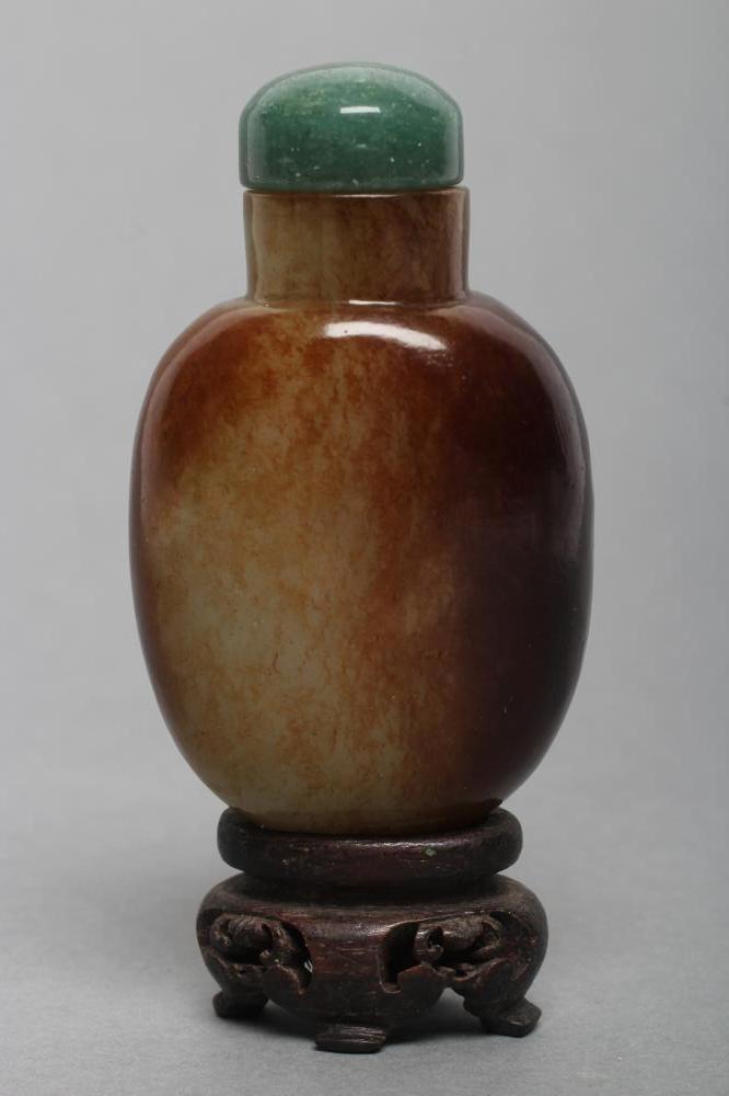 A CHINESE POLISHED OLIVE GREEN JADEITE SNUFF BOTTLE with amber/brown mottling Image