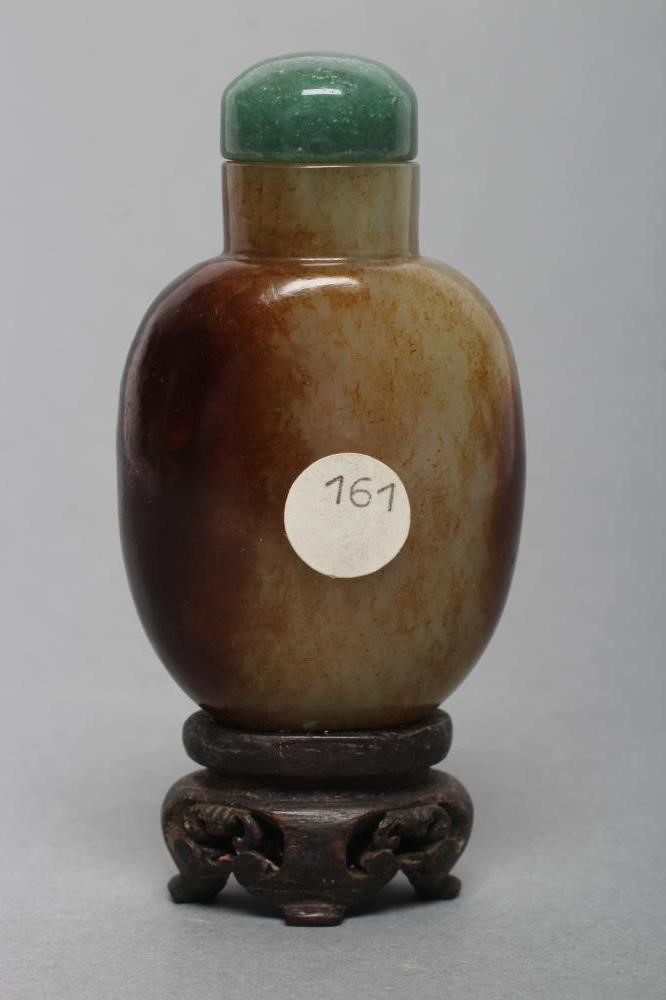 A CHINESE POLISHED OLIVE GREEN JADEITE SNUFF BOTTLE with amber/brown mottling Image