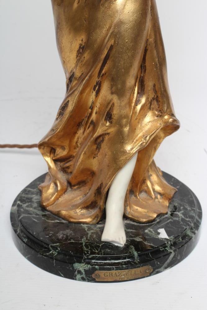 A FRENCH GILDED BRONZE AND BISQUE FIGURAL TABLE LAMP modelled as an Art Nouveau style maiden Image